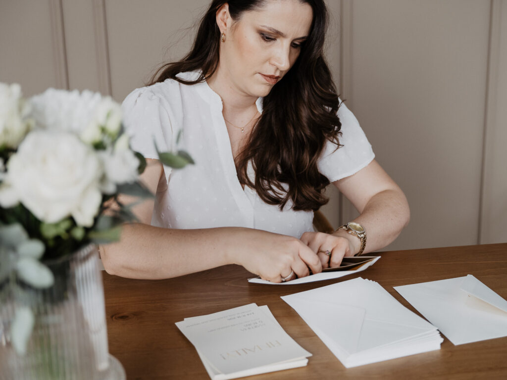 Francine beim Verpacken von Hochzeitseinladungen in den Briefumschlag